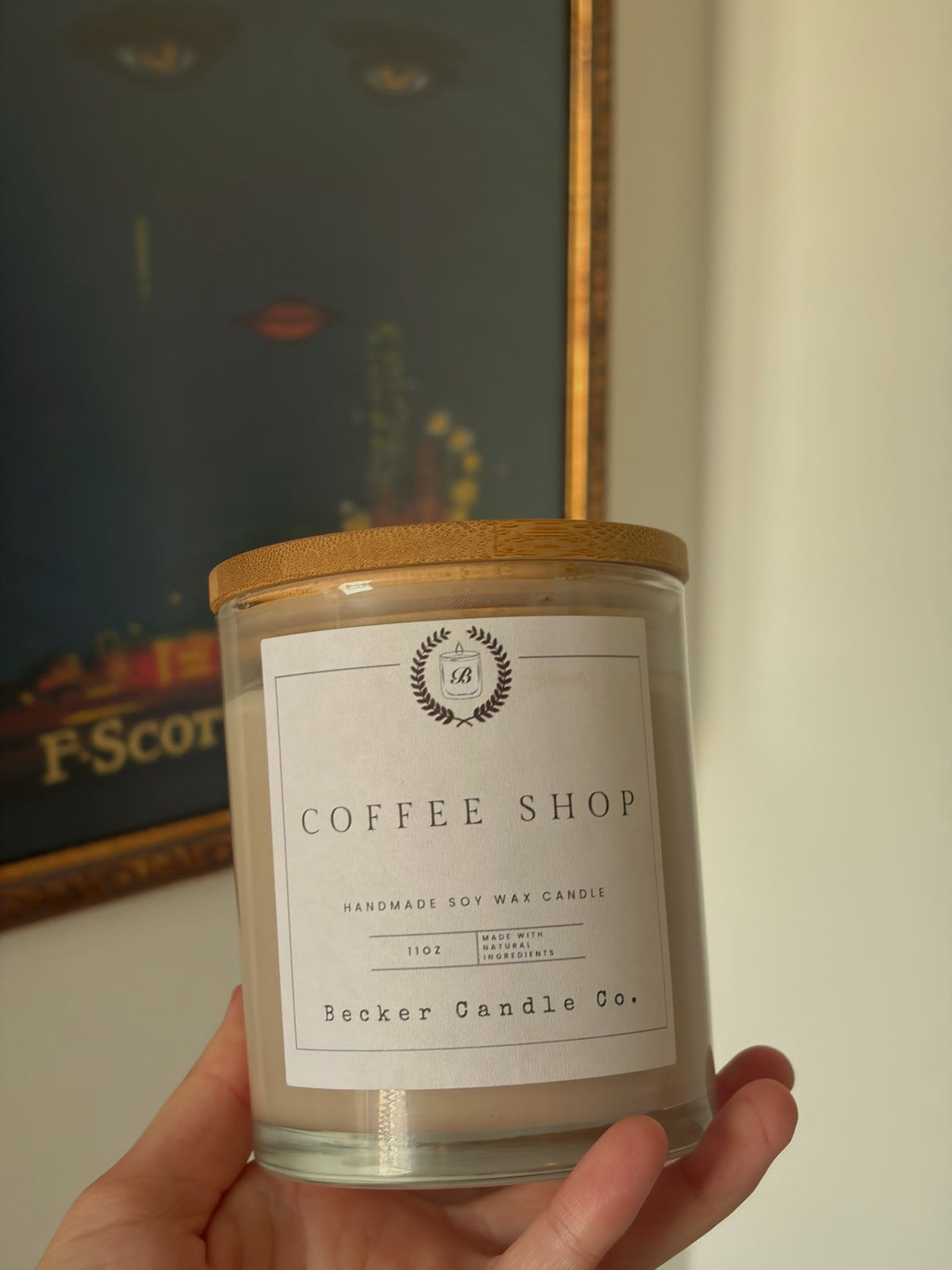 A hand holding a Coffee Shop candle from Becker Candle Co.